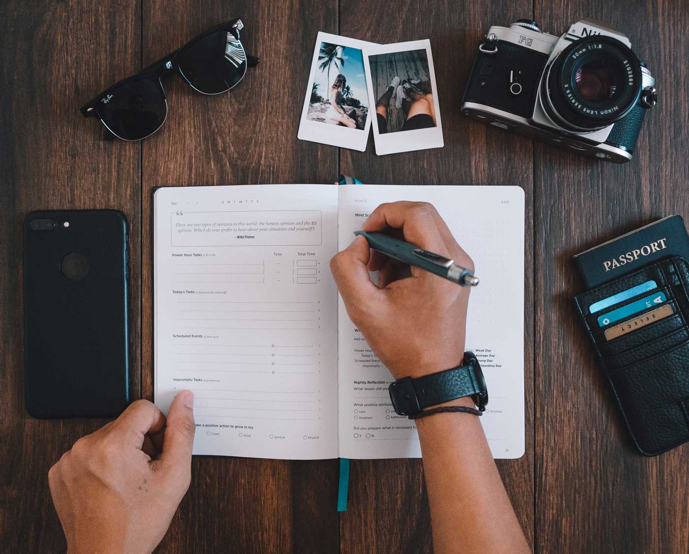 a boy writing in a productivity planner with travel items surrounding him.